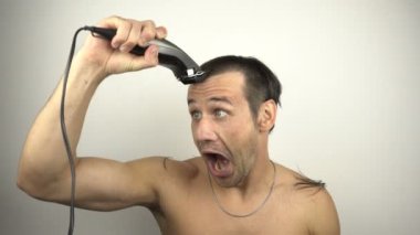 Adam kafasını tıraş eder ve aynaya bakarken yüksek sesle bağırır. Aynanın önünde genç ve komik bir adam evde karantinada otururken saçını saç makasıyla kesiyor..  