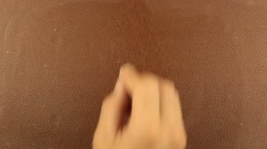 Bir adam kahverengi arka plana tebeşirle soru işareti yazar. Bir adamın eli kahverengi bir tahtaya tebeşirle bir soru işareti yazar..