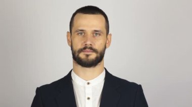 Genç başarılı iş adamı kameraya bakıyor ve gülümsüyor. Genç sakallı iş adamı geniş bir gülümsemeyle kameraya bakıyor. .