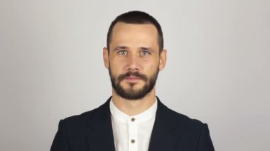 Genç başarılı iş adamı kameraya bakıyor ve gülümsüyor. Genç sakallı iş adamı geniş bir gülümsemeyle kameraya bakıyor. .