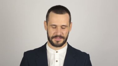 Mavi takım elbiseli genç yakışıklı bir işadamı kameraya bakıyor ve gülüyor..