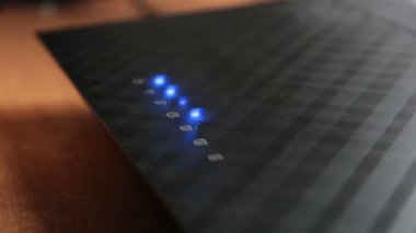 Wi-Fi yönlendiricisinde sinyal göstergesinin yanıp sönmesi. Wi-fi yönlendiricisinde kablosuz ağ göstergeleri yanıp sönüyor. Wi-Fi yönlendirici ve yanıp sönen mavi sinyal göstergeleri..