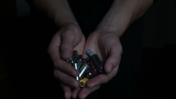 Seorang pria memegang beberapa baterai alkali bekas. Close-up of a mans hand holding used alkaline battery. Konsep perlindungan lingkungan — Stok Video