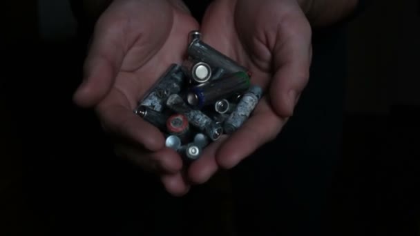 一个人手里拿着一把用过的碱性电池.男子手持用过的碱性电池的特写镜头。环境保护概念 — 图库视频影像