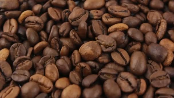 Primer plano de la rotación de granos de café. Granos tostados de café aromático rotan en un plato. — Vídeo de stock