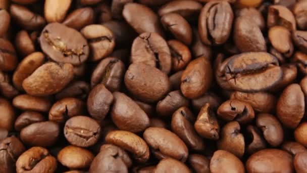 Palone ziarna aromatycznej kawy obracają się na talerzu. Zbliżenie rotacji ziaren kawy. — Wideo stockowe