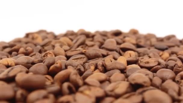 Kahve çekirdekleri dönüşümüne yakın çekim. Kavrulmuş aromatik kahve taneleri bir tabakta döner.. — Stok video