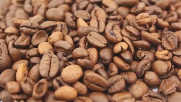 Roasted grains of aromatic coffee rotate on a plate. Close-up of the rotation of coffee beans. — Stock Video