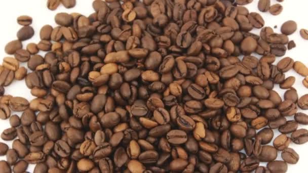 Roasted grains of aromatic coffee rotate on a plate. Close-up of the rotation of coffee beans. — Stock Video