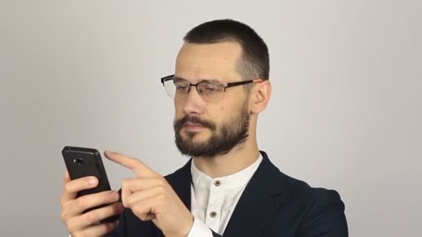 Fiatal jóképű üzletember nézi a híreket az okostelefonján.. — Stock videók