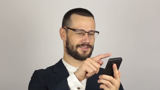 Молодой привлекательный бизнесмен смотрит новости на своем смартфоне. — стоковое видео