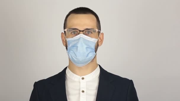 Een jonge succesvolle zakenman doet zijn medisch beschermend masker af en zucht met opluchting. — Stockvideo