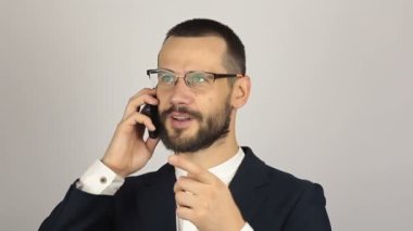 Genç ve başarılı bir iş adamı cep telefonuyla ortaklarıyla konuşuyor..