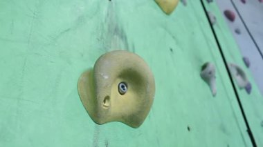 Spor salonunda yeteneklerini geliştiren bir kaya tırmanıcısının eli. Kapalı alanda kaya tırmanışı.