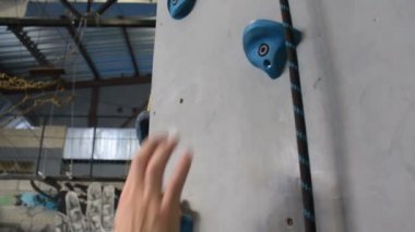 Spor salonunda yeteneklerini geliştiren bir kaya tırmanıcısının eli. Kapalı alanda kaya tırmanışı.