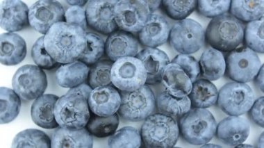 Beyaz arka planda olgun sulu yaban mersinlerinin yakın çekimi. Taze sulu yaban mersinli yakın çekim rotasyonu.