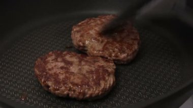 Bir şef ızgaraya köfte koyar. Tavada kızartılmış sulu bir sığır pirzolası. Izgarada burger için sığır pirzolası yakın plan. Bir şef ızgara pirzolayı ters çevirir..