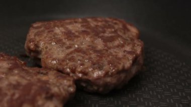 Bir şef ızgaraya köfte koyar. Tavada kızartılmış sulu bir sığır pirzolası. Izgarada burger için sığır pirzolası yakın plan. Bir şef ızgara pirzolayı ters çevirir..