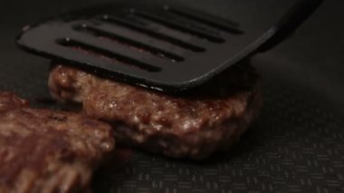 Bir şef ızgaraya köfte koyar. Tavada kızartılmış sulu bir sığır pirzolası. Izgarada burger için sığır pirzolası yakın plan. Bir şef ızgara pirzolayı ters çevirir..