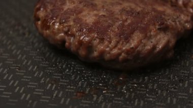 Bir şef ızgaraya köfte koyar. Tavada kızartılmış sulu bir sığır pirzolası. Izgarada burger için sığır pirzolası yakın plan. Bir şef ızgara pirzolayı ters çevirir..