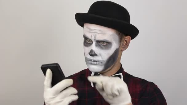一个穿小丑装的可怕男人正在和他的受害者用手机交谈 一个可怕的小丑在讲电话 笑得很厉害 万圣节服装 — 图库视频影像