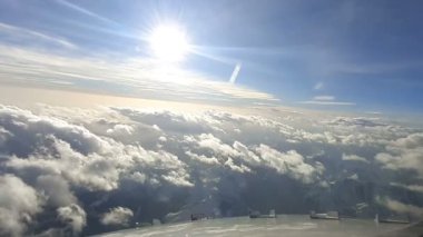 Yolcu uçağı beyaz bulutların üzerinde uçar. Kokpitten bulutların görüntüsü. Uçak penceresinden bulutların görüntüsü.