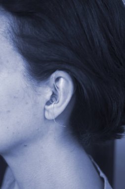 Sağır orta yaşlı Bayan modern dijital teknoloji işitme cihazı kulağına giyiyor.