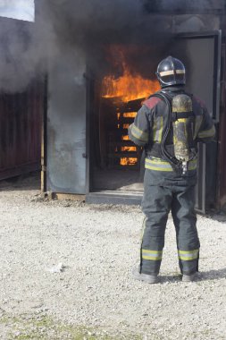 İtfaiyeci yangın söndürme istasyonunu söndürüyor. Acil durum güvenlik tatbikatı prosedürü..