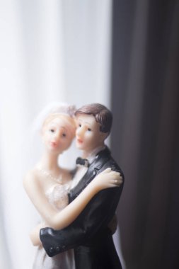 Düğün çifti pasta üstte plastik figürler smokin gece elbisesi, beyaz gelinlik peçesi.