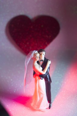 Düğün çifti pasta üstte plastik figürler smokin gece elbisesi, beyaz gelinlik peçesi.