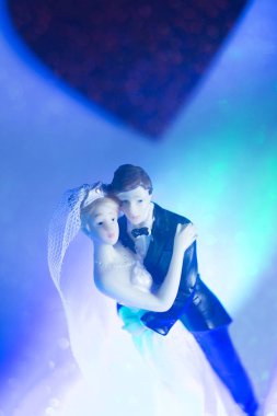 Düğün çifti pasta üstte plastik figürler smokin gece elbisesi, beyaz gelinlik peçesi.