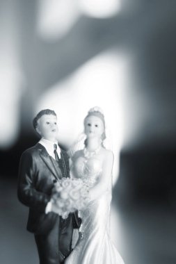 Düğün çifti pasta üstte plastik figürler smokin gece elbisesi, beyaz gelinlik peçesi.