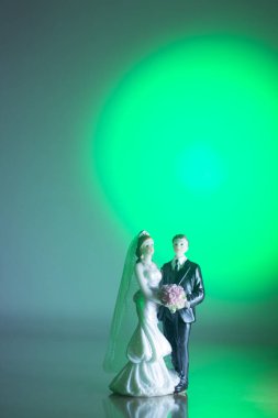 Düğün çifti pasta üstte plastik figürler smokin gece elbisesi, beyaz gelinlik peçesi.