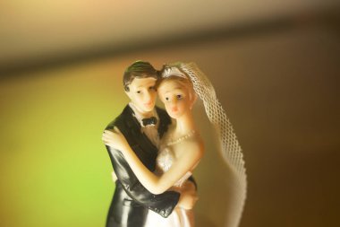 Düğün çifti pasta üstte plastik figürler smokin gece elbisesi, beyaz gelinlik peçesi.