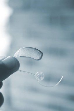 Modern dijital teknoloji işitme cihazı kulağına giyen sağır kıdemli vatandaş adam.