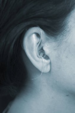 Sağır orta yaşlı Bayan modern dijital teknoloji işitme cihazı kulağına giyiyor.