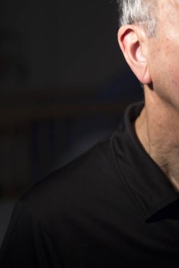 Modern dijital teknoloji işitme cihazı kulağına giyen sağır kıdemli vatandaş adam.