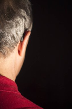 Modern dijital teknoloji işitme cihazı kulağına giyen sağır kıdemli vatandaş adam.