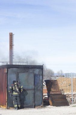 İtfaiyeci tarafından yangın alevleri koyarak pratik matkaplar benzetimini yapmak için itfaiye firefighter eğitim cihazları.