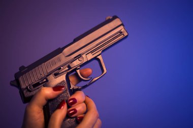 Otomatik tabanca silah tutan kadın eli.