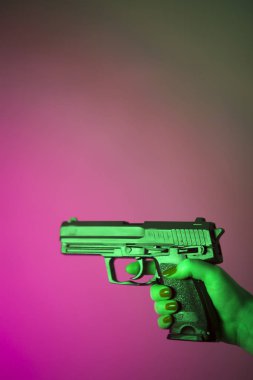 Otomatik tabanca silah tutan kadın eli.