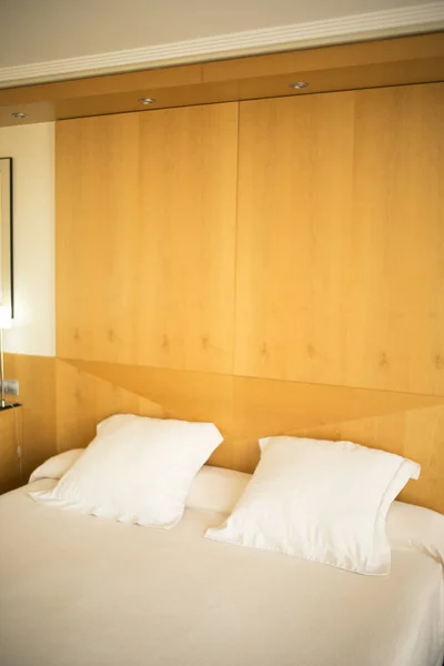 Luxury modern style hotel suite bedroom with bed, sheets, pillows clean and ready for guests.