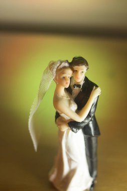 Düğün çifti pasta üstte plastik figürler smokin gece elbisesi, beyaz gelinlik peçesi.