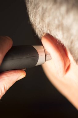 Yaşlı adam kesme iç kulak saç elektrik kesici ile.