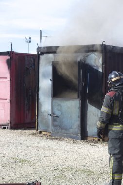 İtfaiyeci yangın söndürme istasyonunu söndürüyor. Acil durum güvenlik tatbikatı prosedürü..