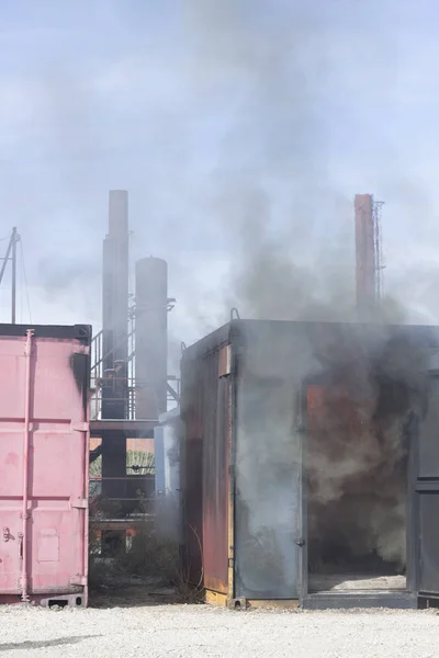 Firefighter putting out fire training station extinguisher backdraft emergency safety drill with ship container.
