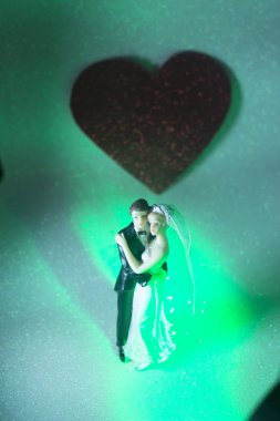 Düğün çifti pasta üstte plastik figürler smokin gece elbisesi, beyaz gelinlik peçesi.