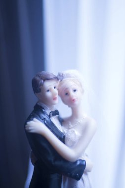 Düğün çifti pasta üstte plastik figürler smokin gece elbisesi, beyaz gelinlik peçesi.