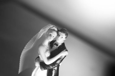 Düğün çifti pasta üstte plastik figürler smokin gece elbisesi, beyaz gelinlik peçesi.