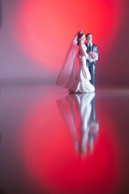 Düğün çifti pasta üstte plastik figürler smokin gece elbisesi, beyaz gelinlik peçesi.